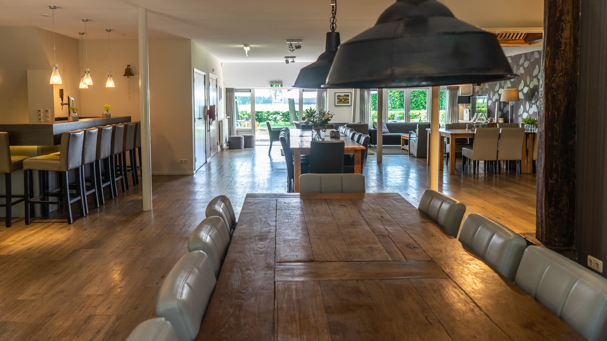 Ruime gezamenlijke eet- en woonkamer met lange houten tafel in Orvelter Hof