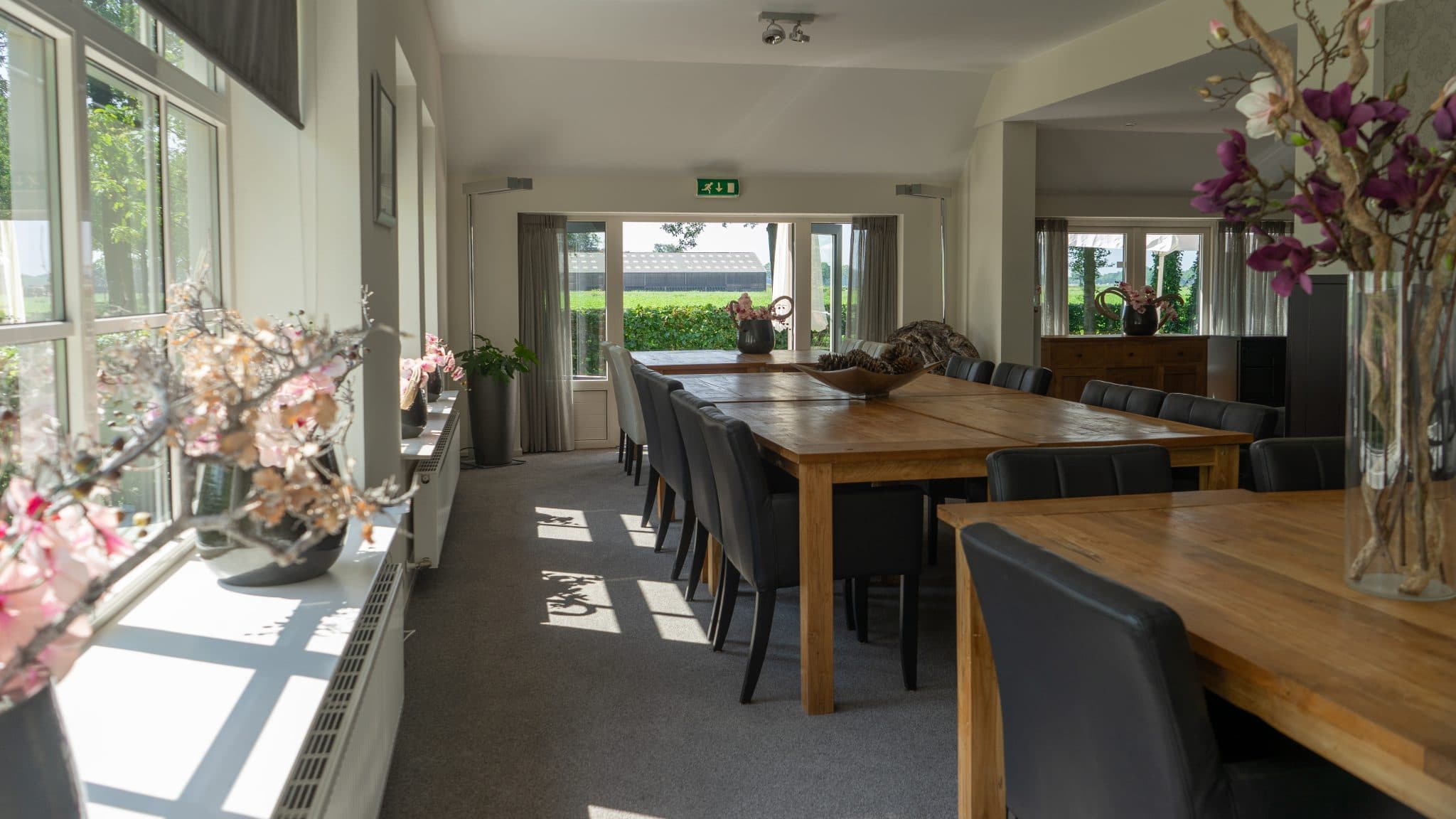 De zaal van Orvelter Hof met lange houten tafels en veel daglicht